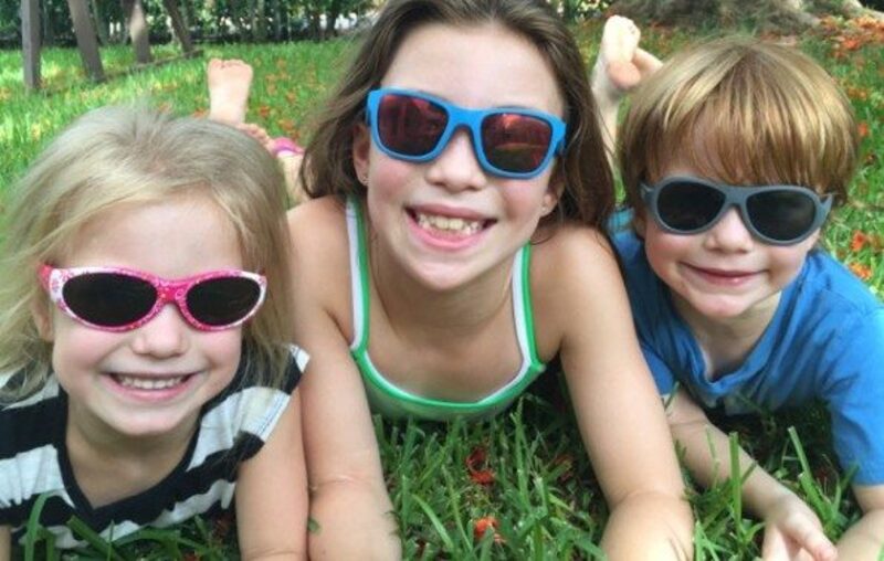 Bambini con occhiali da sole sull'erba